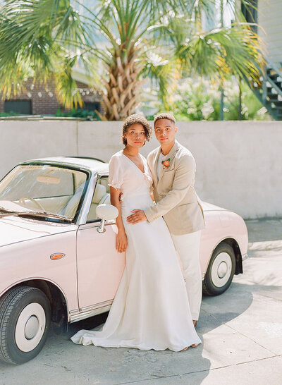 The Pink Figgy vintage pink car with a cute bride and groom for their Charleston elopement