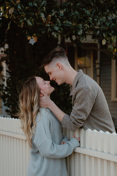 engaged couple smiling at each other over the fence in North Little Rock, Arkansas