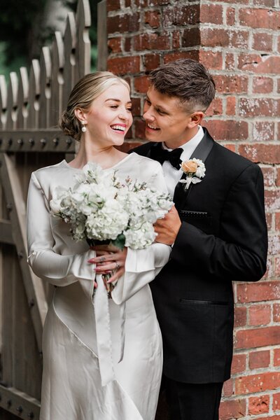 bride and groom posing holding the flower bouquet