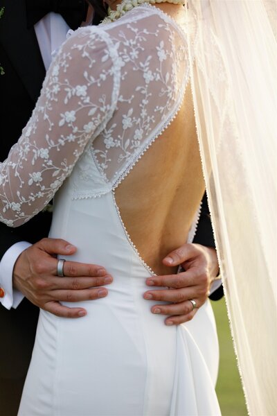A close up of someone with their arms around their partner's waist 