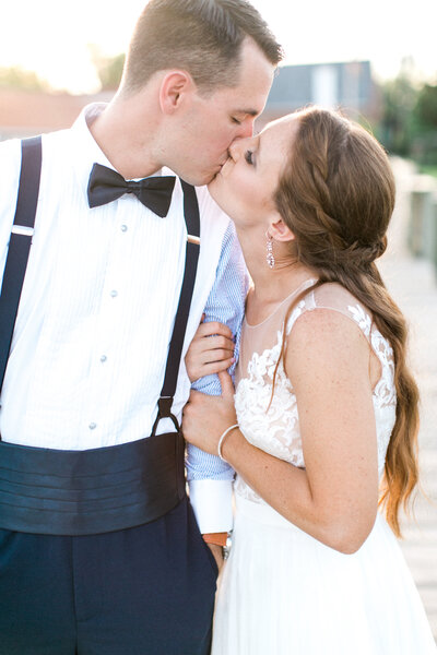 close up of bride and groom kissing at sunset