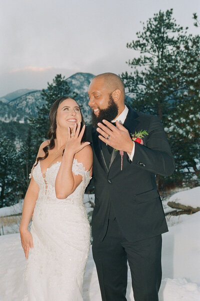 Newlywed couple celebrating in the snow with mountain backdrop – 35mm film Colorado wedding photographer