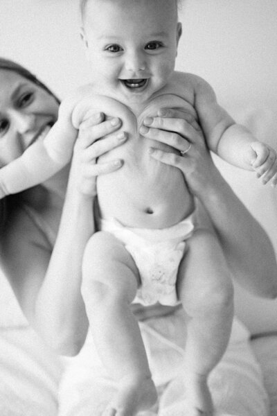 mum holding baby smiling