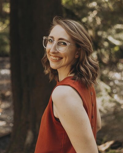 girl holds camera in park smiling