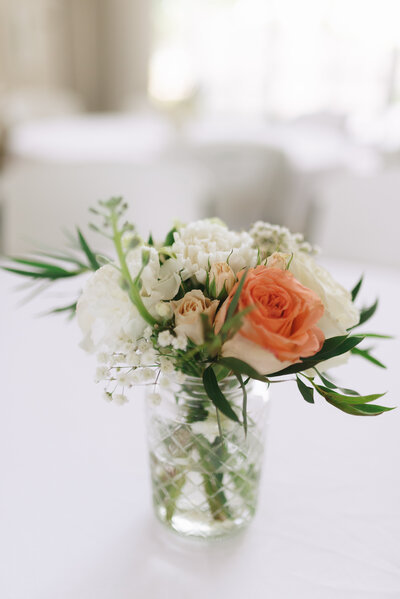 A beautiful wedding bouquet filled with peach and white roses and greenery. 