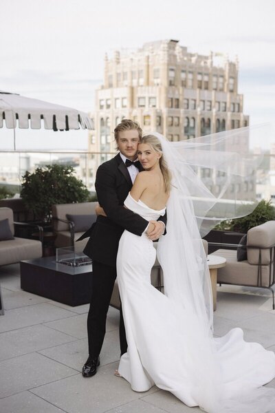 Newlyweds hugging on rooftop of Detroit wedding venue