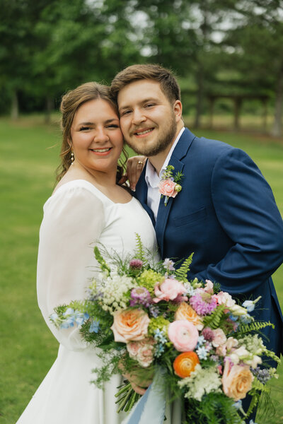 Bride and groom with white and blue bouquet designed by Abby Grace Florals at Greenville SC wedding