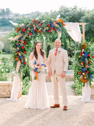 Lindy and Adam, Provence Wedding Couple in front of the arch of flowers
