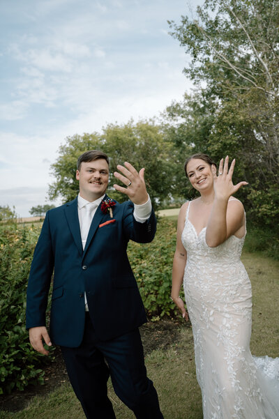 bride and groom showing off their rings after the wedding ceremony