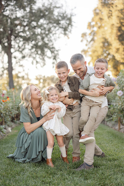 family sitting on log fall photo session