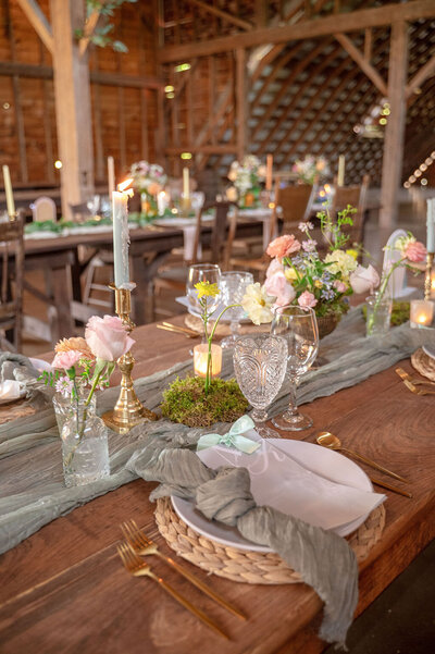 Long wooden wedding tables decorated with flowers and candles