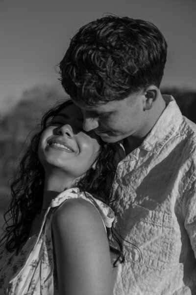 Elizabeth and David snuggling together, in black and white.