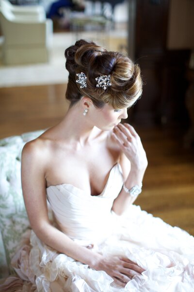 Elegant bride in strapless gown seated in soft window light — editorial wedding photography Germany