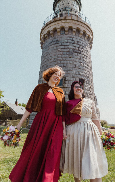 Lesbian couple is posing in the front of lighthouse where they get married in Scandinavia