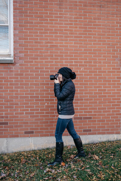 woman holding camera while taking a picture