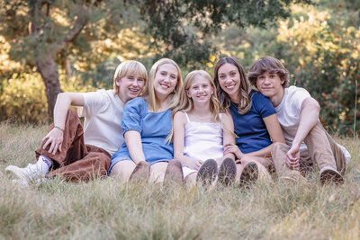 Five young adult cousins sitting on dried grasses at Jeffrey Open Space in Irvine