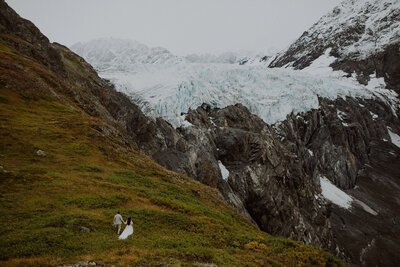 Bride and groom walk on a glacier in Alaska for their elopement
