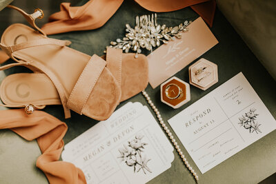 Bohemian wedding flatlay with shoes rings and invitations