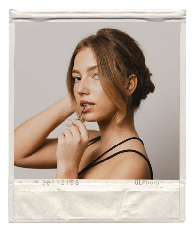Polaroid of a woman with a bobby pin in her mouth during a social media content day for a hair salon. 
