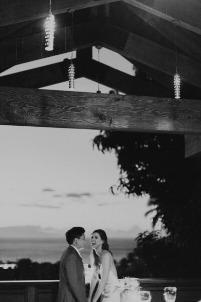 bride and groom laugh under a pergola on their wedding day planned by portland wedding planner 