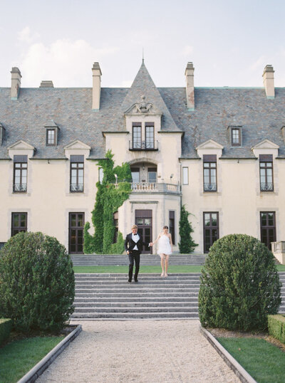 bride and groom running out of oheka castle