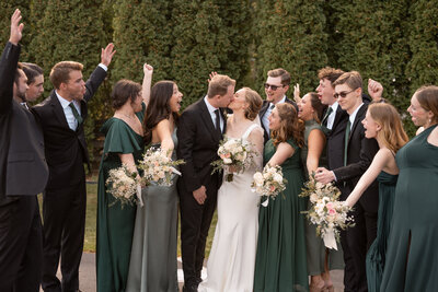 Bridal party cheering while bride and groom kiss taken by CDA wedding photographer.