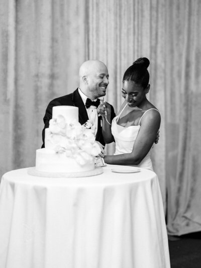 Bride and groom cut their wedding cake with so much joy.