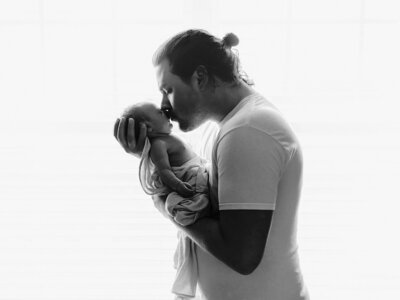 Father holding newborn baby during photography session