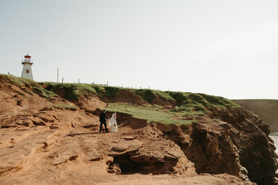 bride and groom share a kiss in front of ocean on wedding day in pei