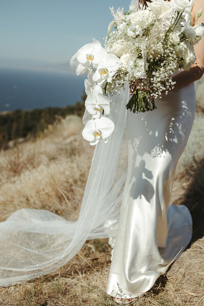 White modern elegant wedding in Penticton with bride holding her flowers