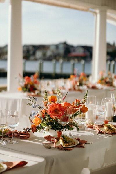 Vibrant floral centerpiece with seasonal flowers and greenery by Leigh Florist, creating a fresh and inviting look for the wedding reception.