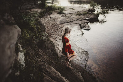 Caroline Weiss walking near natural rock formations, reflecting strength, stillness, and spiritual grounding.