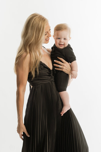 beautiful black woman standing and holding her infant