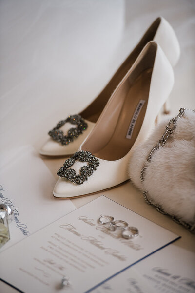 wedding detail of bridal shoes, rings and invitation