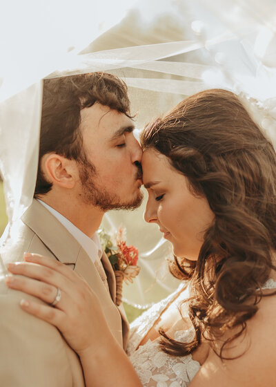 man and woman kissing in forest