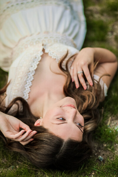 Girl laying on the ground in white dress | Senior Portraits