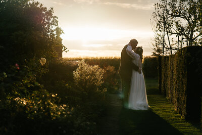 Groom giving bride a piggyback ride at outdoor reception