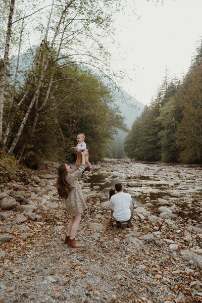 A family portrait of a male and female playing with children at creek near North Bend, Washington