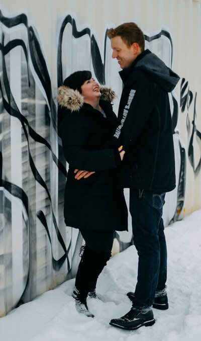 Edmonton couple embracing in their black winter coats