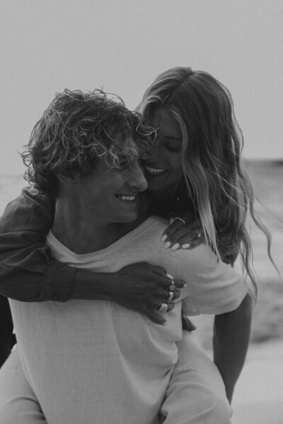 Woman jumping on mans back smiling