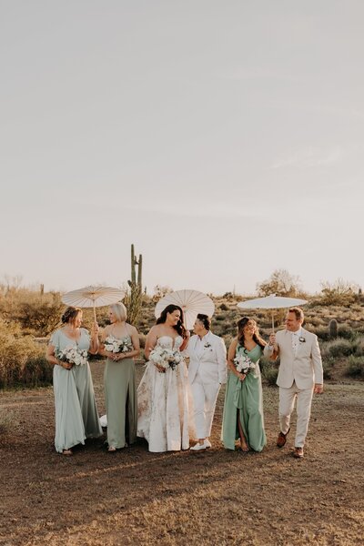 Wedding party walks through the Phoenix desert with parasols