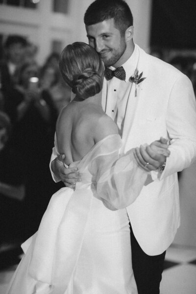 Groom smiles while he has his first dance with his new wife