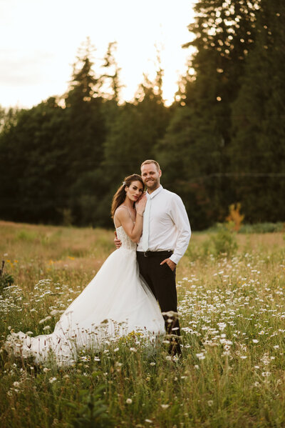 A couple embracing in a field of wild flowers in Maple Ridge, BC