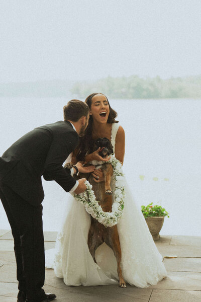 Bride and groom share candid moment with dog during wedding first look photos