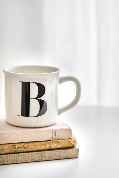 Minimal stock image of coffee mug placed on top of books