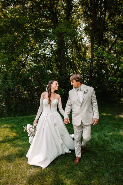 An image from a Milwaukee Wedding Photographer of newlyweds dancing and smiling big in a lawn