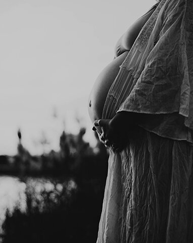 Maternity Photographer, black and white image of pregnant woman holding her belly