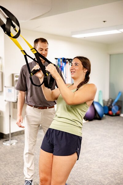 A patient uses TRX bands at Embody's integrative wellness center for physical therapy and whole body wellness