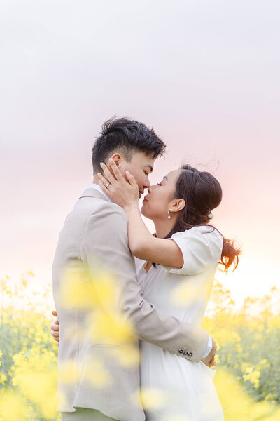 An embracing couple in formal attire almost kissing in flower field in Brisbane family photoshoot.