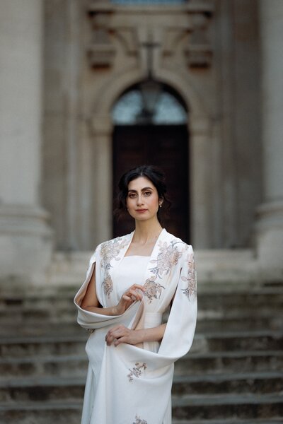 beautiful bride wearing traditional wedding attire posing in front of historical church during a in London